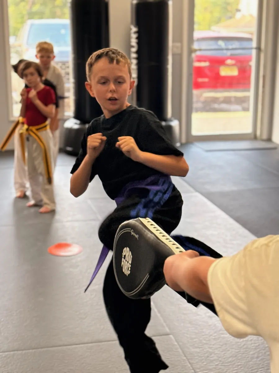 Young martial arts student throwing a kick during class at Rise Up NJ in Atco, NJ