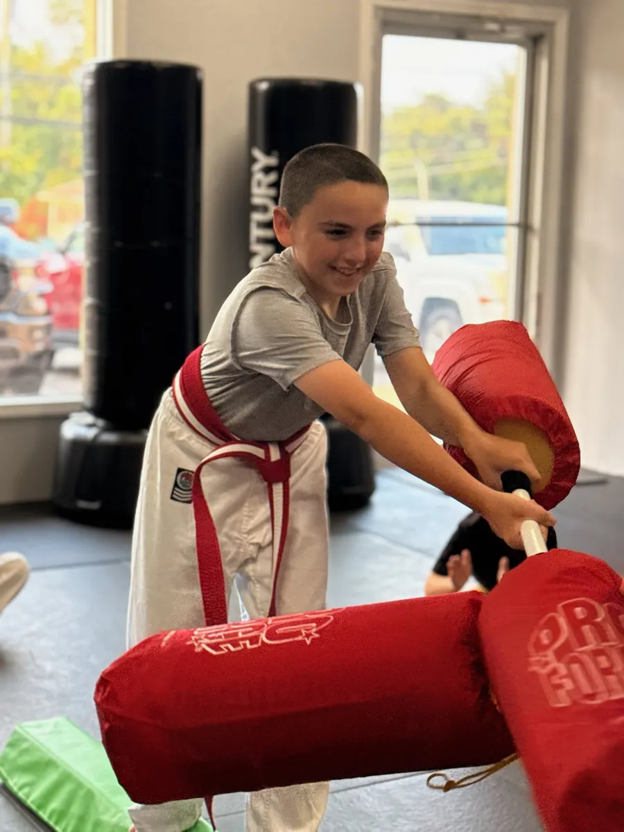 Smiling student working through a pad obstacle course at Rise Up NJ in Atco